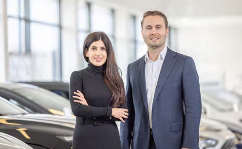 zu sehen ist rechts ein Mann, links eine Frau im Autohaus