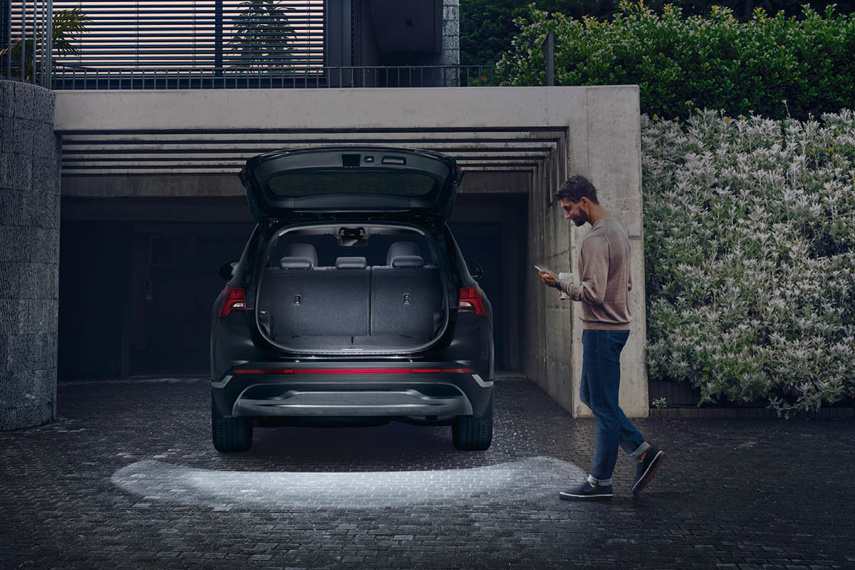 zu sehen ist ein Hyundai SANTA FE mit offenem Kofferraum, daneben steht ein Mann