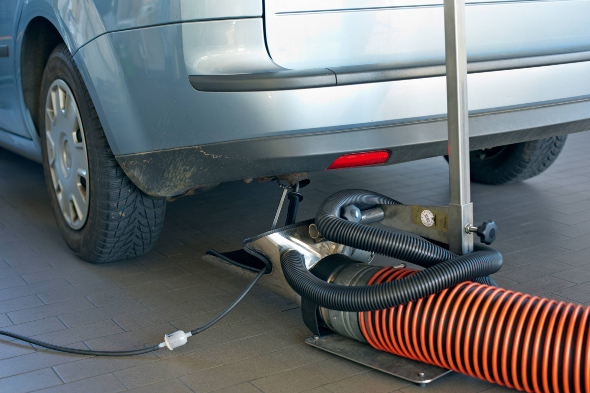 zu sehen ist ein Auto bei dem gerade die Abgase untersucht werden