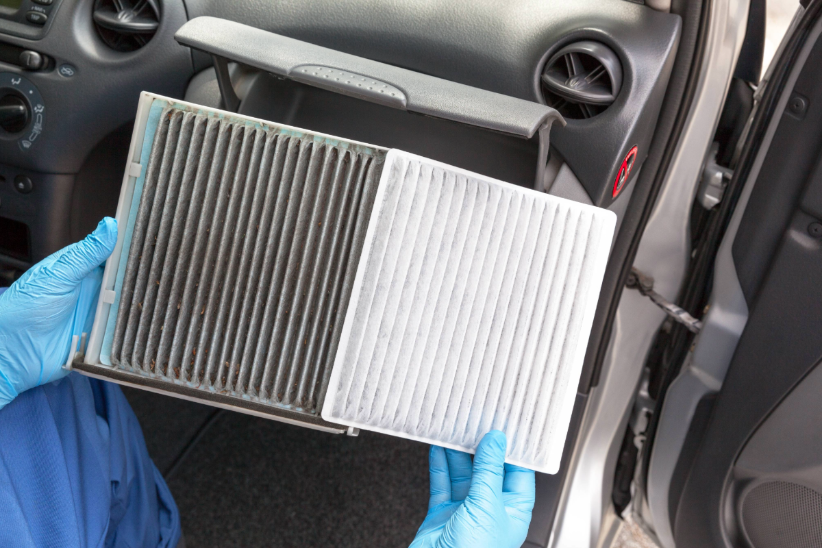 zu sehen ist ein KFZ Mitarbeiter, der die Klimaanlage eines Autos prüft