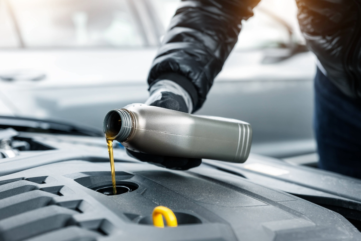 hier sieht man einen KFZ Mitarbeiter der ÖL bei einem Auto nachfüllt